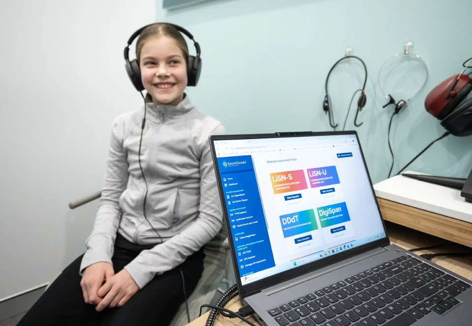 A clinician conducting an auditory processing assessment with a child