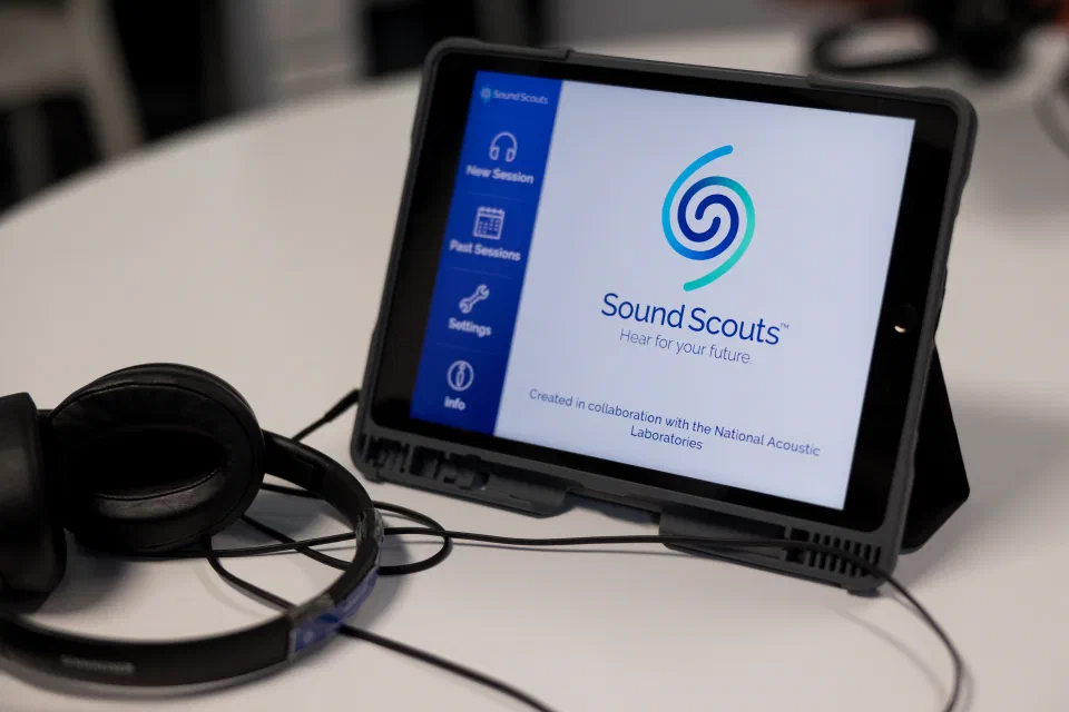 iPad and Headphones on table open on to the Sound Scouts screening app home page.
