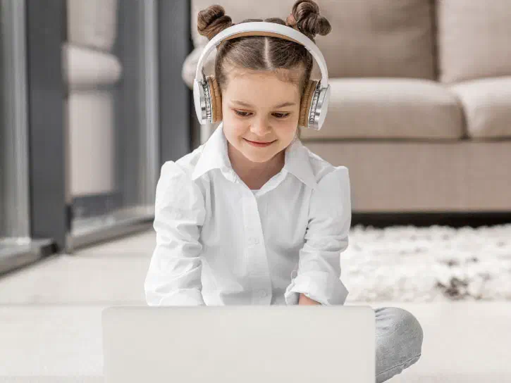 Young girl sitting on the floor wearing headphones
