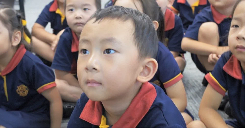 Children sitting on the ground of the classroom learning