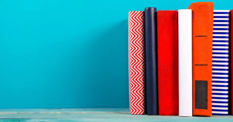 Colorful stack of books against a blue wall