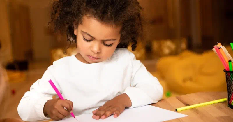 Young girl drawing at a table