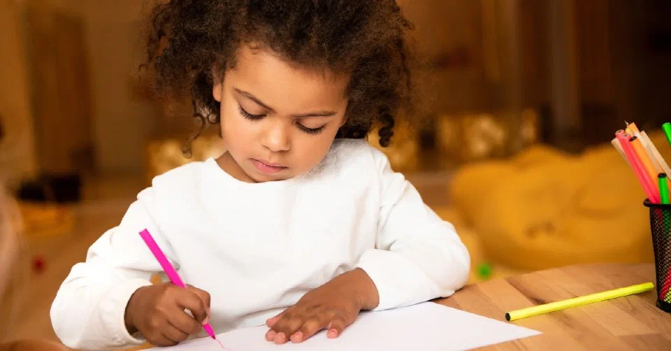 Young girl drawing at a table