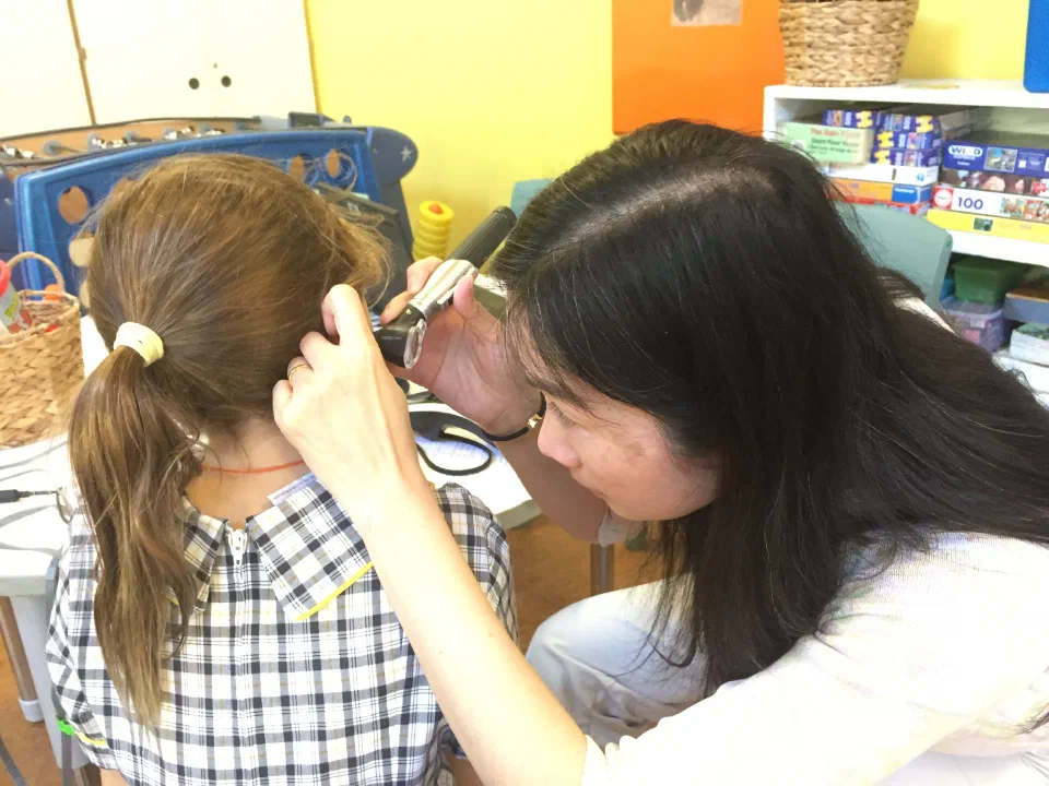 Audiologist looking into a child's ear with an instrument