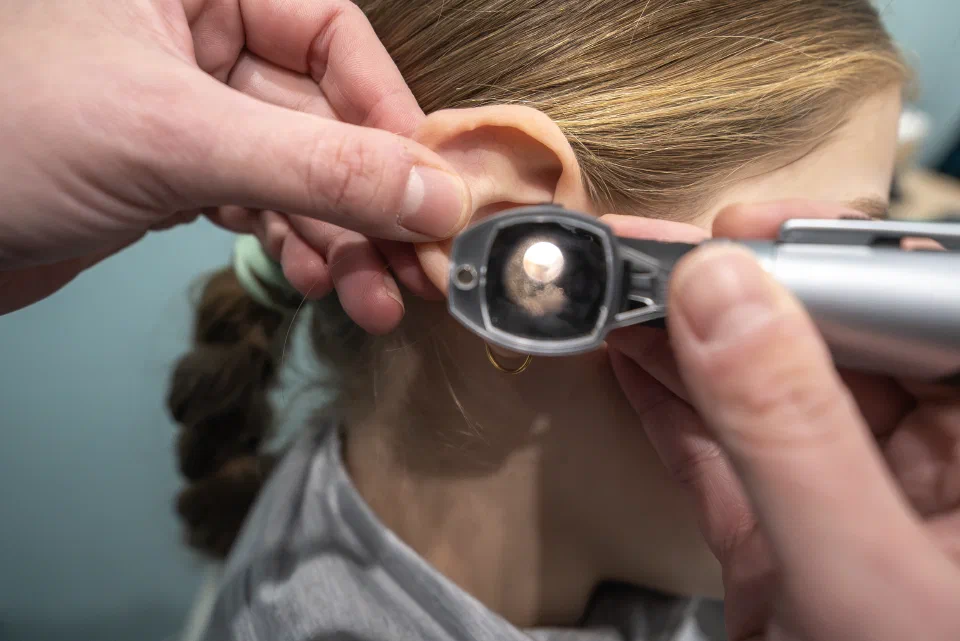 Looking inside the ear of a child using an otoscope.