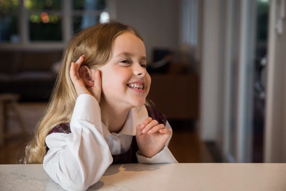 Image of girl with hand up to ear