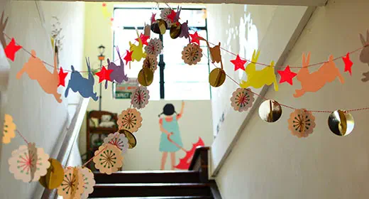 Shot up a set of stairs with handmade garlands hung across the stairway.